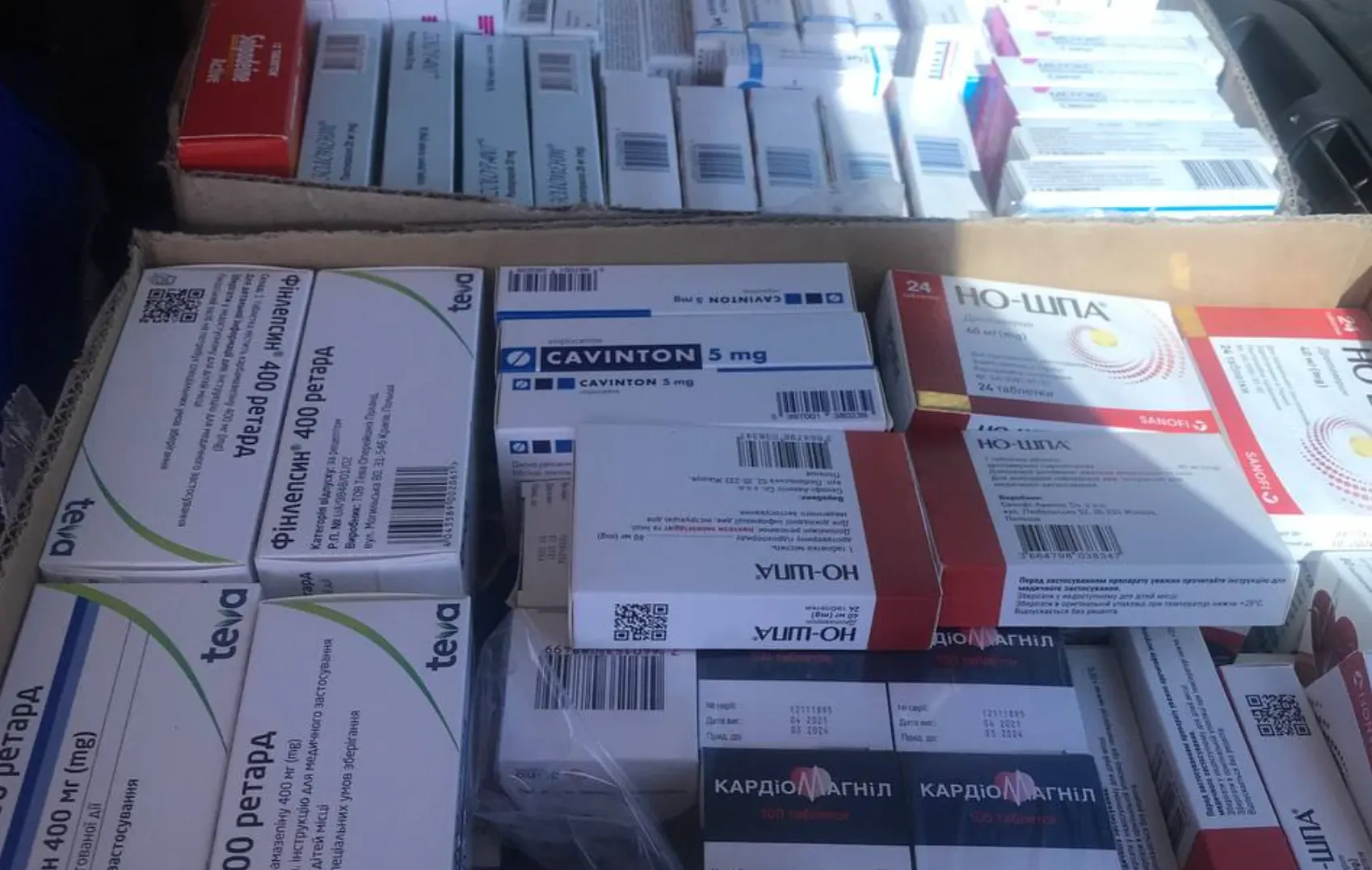 Коробки з упаковками ліків — протисудомні, серцеві, знеболювальні — складені для передачі.